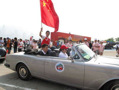 Pop star Andy Lau holding the red flag and leading the procession of vintage convertibles and over 10,000 participants.