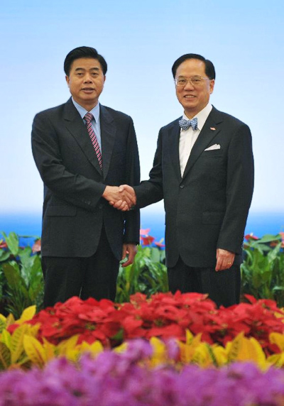 Mr. Donald Tsang, Chief Executive of the HKSAR (right), and Mr. Huang Hua Hua, Governor of Guangdong Province, shaking hands before the conference.