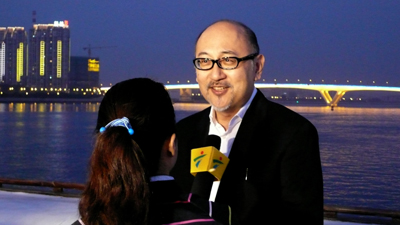 The interview taking place against the backdrop of nighttime Zhujiang