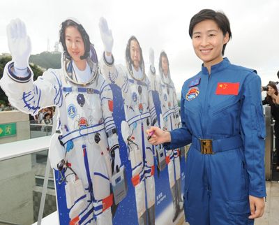 中國首名女太空人劉洋成為市民關注的焦點。她在參觀山頂時，為自己的紙板公仔簽名。