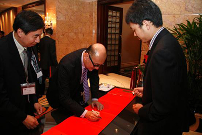 Mr. Kit Szeto signing his name upon his arrival