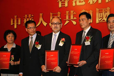 司徒傑先生(中)作為其中贊助機構代表接受紀念狀。左二為香港信報總編輯陳景祥先生，左四為深圳報業集團社長、香港商報社長黃揚略先生。