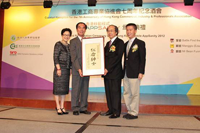 Mr. Peter H. Pang accepting his commemorative plaque with his wife and son