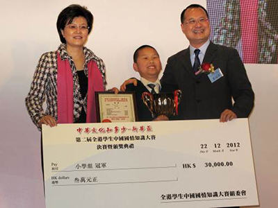 從左至右：外交部駐港特派員公署副特派員姜瑜女士（左一）和新華集團主席蔡冠深先生（右一）為小學組冠軍頒獎。