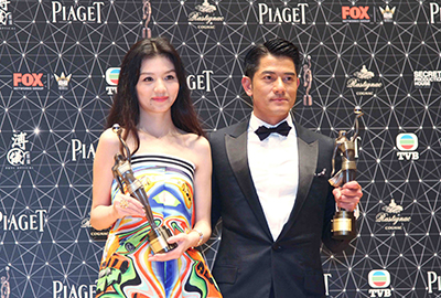 Ms. Jessie Li (left) and Mr. Aaron Kwok (right) being presented with the coveted trophy.